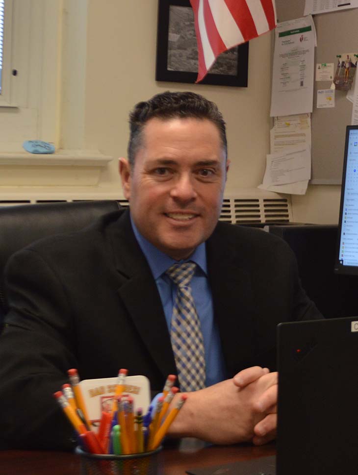 Principal Joseph Santicerma sits at his desk in office