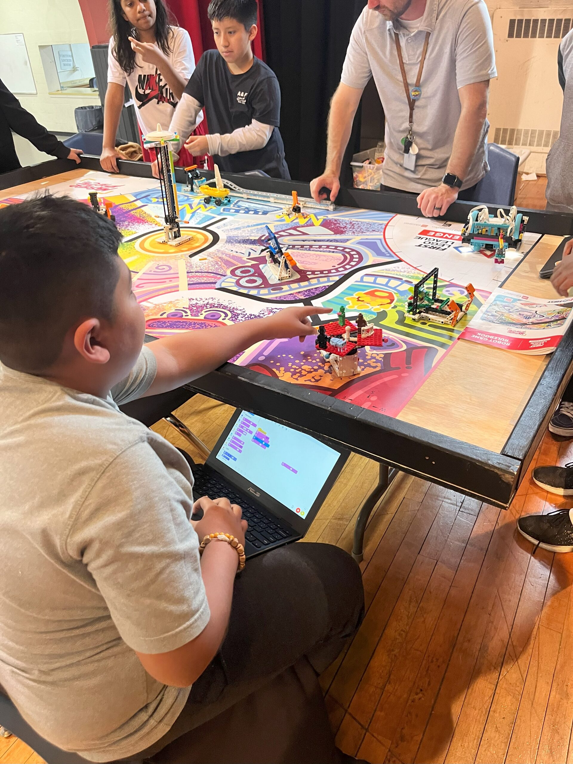 Students work on robotics experiments around a colorful table